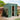 Dark green metal storage shed with open front double doors and two roof vents