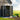 Open metal storage shed with double doors, roof vents, and garden tools
