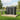 Metal storage shed with two closed doors, pent roof, dark grey panels on wooden base