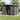 Gray metal garden storage shed with sliding door open and shelving inside