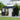 Metal storage shed with open double doors, front windows, and vent panels on wall