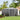 Gray metal lockable garden storage shed with double doors and apex roof, outdoor setting.