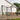 Wall-mounted canopy gazebo with dark frame and clear polycarbonate roof panels