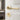 Gold door lock cylinder with round escutcheon and lever handle on white door