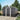 Metal garden storage shed with sliding doors closed, dark gray corrugated panels, vents