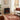 Freestanding electric fireplace heater in living room setting with red flame glow behind glass
