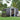 Metal garden storage shed with sliding door open, dark gray walls, roof vents
