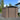 Brown metal garden storage shed with black apex roof, sliding double doors, and vented panels