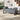 Grey upholstered storage bench with rounded armrests and black tapered legs