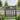 Wooden garden pedestrian gate with crisscross brace and vertical slats, dark gray finish.