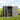Open metal garden storage shed with roof vents and visible tools inside