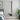 Tall rectangular acrylic mirror tile panel reflecting a bedroom bed