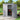 Gray plastic garden storage shed with double doors open showing shelving inside