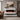 White wall-mounted electric fireplace with orange flames and dark burner base
