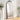 Black arched freestanding mirror with ornate metal top frame, full-length view