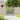 Wooden garden pedestrian gate with X-brace panel and vertical slats, weathered gray look.