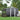 Metal garden storage shed, dark gray corrugated walls, white trim, vented apex roof