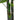 Artificial tropical tree stem close-up with faux bamboo texture and green leaf tips
