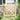 Light wood fence gate with vertical slats, diagonal brace, and black latch hardware