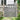 Gray wooden garden gate with vertical pickets, frame posts, and double horizontal rails