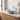 Light grey round countertop washbasin with chrome faucet and pop-up drain
