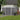 Grey metal storage shed with apex roof and closed double doors