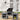 Foldable camping kitchen stand with wind shield, black grill center and two open side cabinets