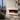 White wall-mounted electric fireplace with glowing flame effect in a wide open firebox.