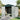 White storage shed with open double doors and visible interior wall and roof vents