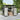 Metal garden storage shed with open doors, storage shelves and stacked firewood
