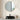 Round wall mirror with gold metal border above a dark countertop sink setup.
