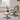 Light brown lounge chair on swivel base with footstool beside it