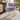 Purple velvet vanity chair stool with wide rounded seat, button-tufted back, and white legs