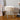 White round plush footstool with padded top and white metal legs