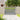 Outdoor wooden fence gate with vertical slats and metal latch, set in garden