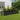 Dark grey oval raised garden bed planter filled with flowering plants along the edge