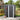 Black metal storage shed with front door, vertical panel walls, and roof overhang