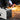 Multi-process welding machine with front control panel and side handle, producing sparks