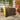 Brown wicker foldable bin storage screen with caster wheel at bottom