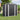 Black metal garden shed with white frame, double doors, and roof vents