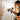 Handheld HVLP paint sprayer spraying tool with 1200ml cup, shown in use on a wall