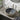 Round ceramic countertop washbasin with dark speckled bowl and leaf-patterned rim