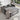 Grey sofa bed with pull-out mattress, two pillows, and draped fabric throw