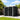 Metal bike storage shed with black double doors and white frame, pent roof
