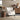Beige upholstered armchair with studded trim and vertical tufted backrest