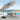 Light grey cantilever parasol open over patio table with dark weighted base